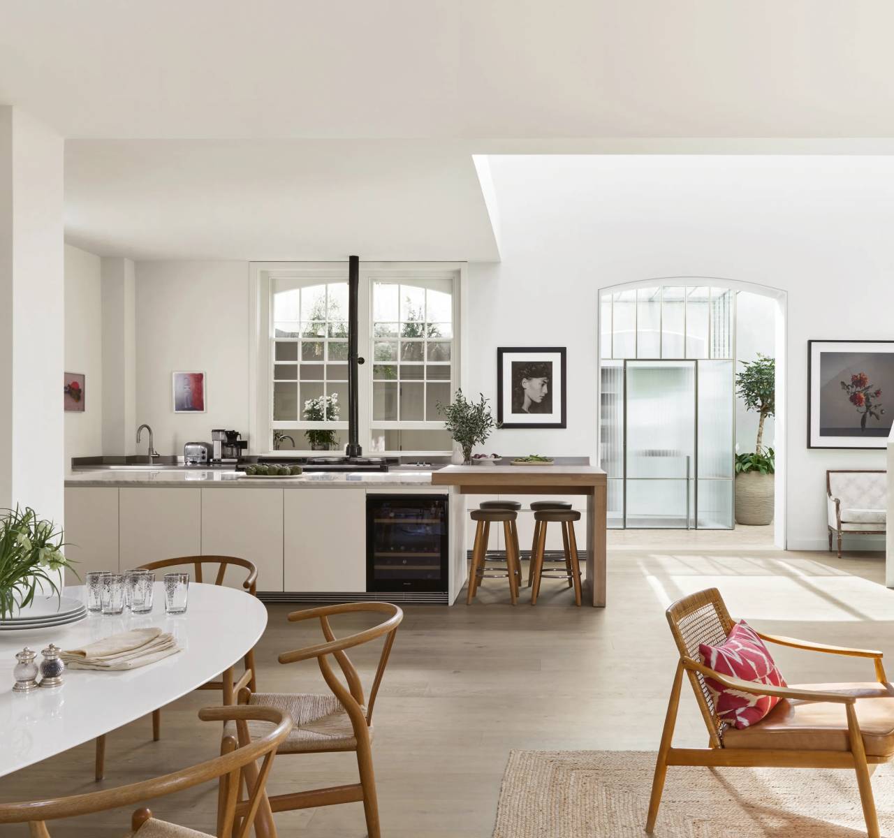 Beautifully renovated open-plan living room with oak flooring and sage green furniture by Home Construct Haven